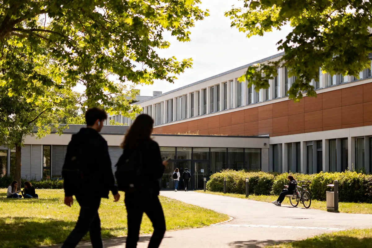 Étudiants marchant vers un bâtiment moderne d'une école de management et innovation en France
